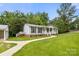 Single-story home with a metal roof, covered porch and sidewalk at 1983 Burkin Rd, McConnells, SC 29726