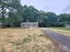 Charming single-story house with a gravel driveway, lush trees and manicured front yard at 2070 Stirewalt Rd, China Grove, NC 28023