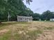 Cozy single-story home nestled among mature trees with a well-manicured lawn and blue front door at 2070 Stirewalt Rd, China Grove, NC 28023