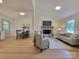 Bright, open-concept living room with a brick fireplace, hardwood floors, and modern furnishings at 2070 Stirewalt Rd, China Grove, NC 28023