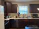 A kitchen with dark wooden cabinets, stainless steel appliances, and natural light at 211 Hidden Lakes Rd, Statesville, NC 28677