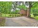 Brick house and driveway surrounded by mature trees, offering a serene and private outdoor space at 2301 Seth Thomas Rd, Charlotte, NC 28210