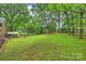 Lush, expansive backyard with mature trees, offering a serene and private outdoor space, plus a storage shed at 2301 Seth Thomas Rd, Charlotte, NC 28210
