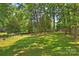 Spacious backyard with mature trees and a storage shed, perfect for outdoor activities and relaxation at 2301 Seth Thomas Rd, Charlotte, NC 28210