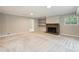 Basement featuring a fireplace with stone surround, built-in shelves, and neutral colored carpet at 2301 Seth Thomas Rd, Charlotte, NC 28210