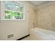 Bathroom with a tiled shower over bathtub and a window with leafy, green, backyard views at 2301 Seth Thomas Rd, Charlotte, NC 28210