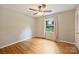 Bedroom with hardwood floors, ceiling fan, and a window providing natural light and backyard views at 2301 Seth Thomas Rd, Charlotte, NC 28210