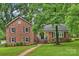 Charming two-story brick home with a well-manicured lawn and mature trees providing shade at 2301 Seth Thomas Rd, Charlotte, NC 28210