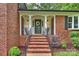 Inviting front porch with brick steps, black railings, and a decorative wreath on the front door at 2301 Seth Thomas Rd, Charlotte, NC 28210