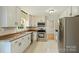 Stylish kitchen with stainless steel appliances, granite countertops and white cabinets, adjacent to dining space at 2301 Seth Thomas Rd, Charlotte, NC 28210