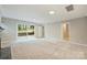 Bright living room featuring sliding glass doors and neutral carpet that connects to other parts of the home at 2301 Seth Thomas Rd, Charlotte, NC 28210