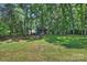 Charming backyard shed surrounded by mature trees, providing ample storage space with room for firewood at 2301 Seth Thomas Rd, Charlotte, NC 28210