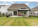 Backyard with sliding glass door, patio, grill, black fence, gazebo with table and hammock, and green lawn at 2317 Trollinger Dr, Catawba, NC 28609