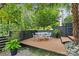 Relaxing backyard deck featuring an outdoor dining set, set against a backdrop of lush greenery and trees at 2424 Cumberland Ave, Charlotte, NC 28203