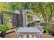 Beautiful backyard deck showcasing an outdoor dining area, complemented by mature trees and stylish landscaping at 2424 Cumberland Ave, Charlotte, NC 28203