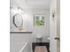 Bright bathroom featuring black mosaic tile floor, white subway tile, modern fixtures and decor, and a window offering a wooded view at 2424 Cumberland Ave, Charlotte, NC 28203