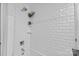 Close-up of tiled shower, complete with showerhead, faucet, and convenient shelves for toiletries and decorations at 2424 Cumberland Ave, Charlotte, NC 28203