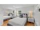 Well-lit bedroom with hardwood floors, queen-size bed, mirrored closet doors, and matching nightstands with lamps at 2424 Cumberland Ave, Charlotte, NC 28203