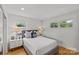 Comfortable bedroom with hardwood floors, two windows, a queen-size bed with plush pillows, and matching nightstands with lamps at 2424 Cumberland Ave, Charlotte, NC 28203