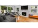 Bright living room with hardwood floors, a modern sofa, a fireplace, and large windows offering outdoor views at 2424 Cumberland Ave, Charlotte, NC 28203