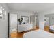 View of the bedroom with hardwood floors, leading to the ensuite bathroom and dresser with decorative mirror, creating seamless flow at 2424 Cumberland Ave, Charlotte, NC 28203
