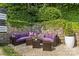 Cozy outdoor patio with a purple couch, neutral stone ground cover, and lush ivy-covered stone wall at 2424 Cumberland Ave, Charlotte, NC 28203