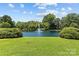 Beautiful pond with a fountain surrounded by lush greenery and blue sky at 2424 Cumberland Ave, Charlotte, NC 28203