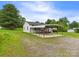 Cozy single-story home with a gravel driveway and a metal carport in a serene, tree-filled setting at 271 Nc 16 N Hwy, Taylorsville, NC 28681