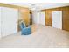 Carpeted living room with wood paneling, blue armchair, and views to bathroom and exterior door at 271 Nc 16 N Hwy, Taylorsville, NC 28681