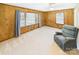 Cozy living room with wood paneling, two large windows, and a comfortable blue armchair at 271 Nc 16 N Hwy, Taylorsville, NC 28681