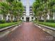 An elegant condo entrance with a brick walkway framed by lush landscaping and mature trees offers a welcoming arrival at 300 W 5Th St # 339, Charlotte, NC 28202