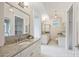 This spacious bathroom has a granite countertop, white cabinets, a vanity area and lots of storage at 3032 Kings Manor Dr, Matthews, NC 28104