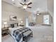 Spacious bedroom featuring neutral walls, ceiling fans and a sitting area with ottoman at 3032 Kings Manor Dr, Matthews, NC 28104