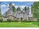 Elegant stone and brick home with manicured landscaping and lush green lawn at 3032 Kings Manor Dr, Matthews, NC 28104