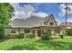 Stately brick home with lush green lawn, manicured hedges and a covered patio at 3032 Kings Manor Dr, Matthews, NC 28104