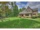 Stunning home with brick exterior, large lawn, and covered patio surrounded by lush landscaping at 3032 Kings Manor Dr, Matthews, NC 28104