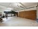Spacious garage featuring a car lift, ample lighting, and stylish wooden doors at 3032 Kings Manor Dr, Matthews, NC 28104