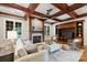 Living room with coffered ceilings, a stone fireplace, built-in shelving, and hardwood floors at 3032 Kings Manor Dr, Matthews, NC 28104