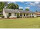 Charming one-story home with brick exterior, lush lawn, and rocking chair front porch at 309 Ogden Dr, Gastonia, NC 28056