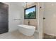 Elegant bathroom featuring a soaking tub, large window, and a separate glass-enclosed shower at 309 Sain Rd, Statesville, NC 28625