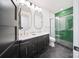 Modern bathroom featuring double vanity, sleek black hexagonal floors, and a walk-in shower with stylish green tile at 309 Sain Rd, Statesville, NC 28625