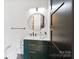 Elegant bathroom with a green vanity, round mirror, modern fixtures, and stylish tile flooring at 309 Sain Rd, Statesville, NC 28625