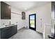 Well-lit mud room with sleek black cabinets, stainless sink, and an exterior door leading to the yard at 309 Sain Rd, Statesville, NC 28625