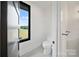 Neat powder room featuring a modern toilet and black framed window with a great view of nature at 309 Sain Rd, Statesville, NC 28625