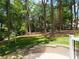 Landscaped backyard featuring a retaining wall and a backdrop of mature trees providing shade and privacy at 3601 Woody Grove Ln, Charlotte, NC 28210
