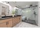 A modern bathroom features marble walls, a walk-in shower with glass door, and double sink vanity at 3601 Woody Grove Ln, Charlotte, NC 28210