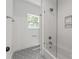 This bathroom features a shower-over-tub, and modern geometric tiled floors at 3601 Woody Grove Ln, Charlotte, NC 28210