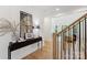 Welcoming entryway with black mirror, staircase, and decor on console table at 3601 Woody Grove Ln, Charlotte, NC 28210