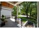 Covered front porch with stone flooring and black railing overlooking manicured lawn at 3601 Woody Grove Ln, Charlotte, NC 28210