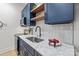 Stylish laundry room with marble countertops, navy blue cabinets, and open shelving at 3601 Woody Grove Ln, Charlotte, NC 28210
